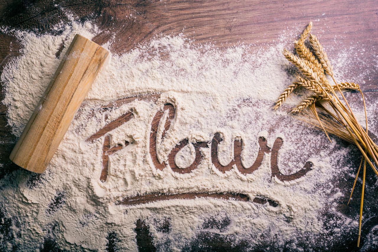 Crafting Captivating Headlines: Your awesome post title goes here Flour scattered on a wooden table spelling 'flour,' with a rolling pin and wheat stalks nearby.